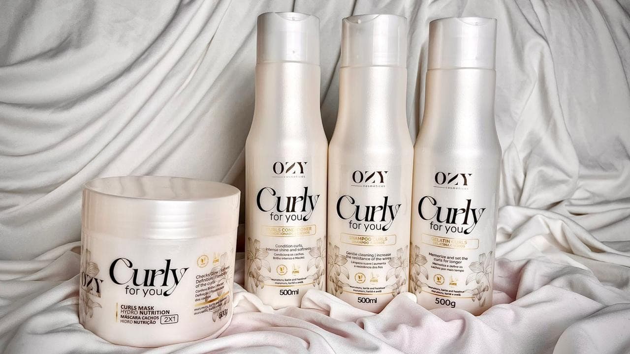 Kit capilar Ozy Curly for You completo com máscara 2 em 1, shampoo, condicionador e creme de pentear sobre um tecido branco.